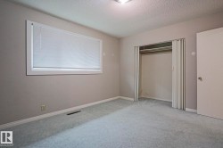 Carpeted flooring, window with blinds, wall-mounted light fixture, and closet with bi-fold doors - 