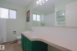 Extended vanity with an integrated sink and base cabinetry, large wall-mounted mirror, and tile flooring - 
