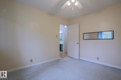 Carpeted flooring with light-colored walls and a ceiling fan with integrated lighting - 