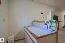 Built-in cabinetry with wood-finish trim, white countertop, and a partially recessed sink - 