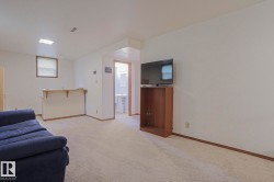 Carpeted living area featuring a built-in bar, a window, and a recessed light fixture - 