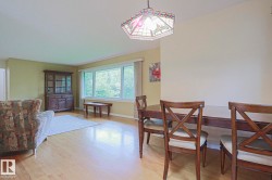 Hardwood-finish flooring, ample natural light from large windows, and an overhead decorative light fixture - 
