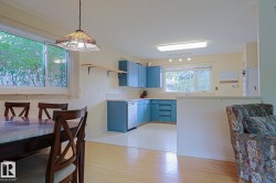Kitchen featuring blue cabinetry, white countertops, and white appliances - 