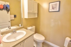 Bathroom featuring a single vanity with an integrated sink, a wall-mounted mirror, and a two-piece toilet - 