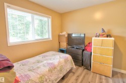 Room featuring wood-finish flooring, a double window with white blinds, and warm-toned wall paint - 
