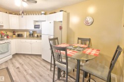 Compact kitchen featuring white cabinetry, light countertops, and wood-finish flooring - 