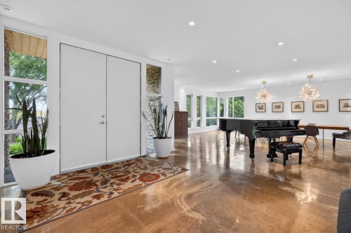 Double entry doors with sidelight windows, polished concrete flooring, recessed lighting, and two contemporary light fixtures - 14A Birch Drive, St. Albert, AB 