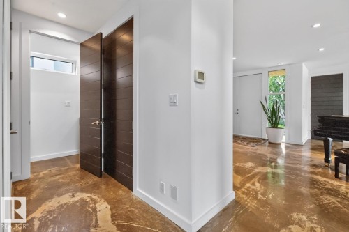 Modern interior with unique patterned flooring, recessed lighting, and a transom window - 14A Birch Drive, St. Albert, AB 