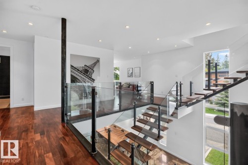 Hardwood flooring, glass railings, open-riser staircase, recessed lighting, and expansive window - 14A Birch Drive, St. Albert, AB 