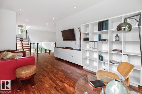 Hardwood flooring throughout, built-in shelving, white walls, and recessed lighting - 14A Birch Drive, St. Albert, AB 