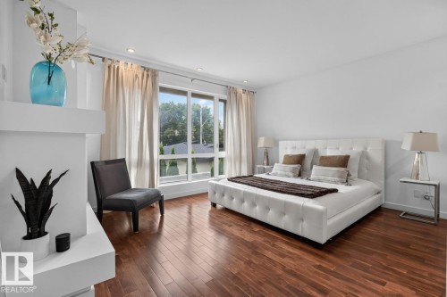 Hardwood flooring, recessed lighting, expansive window with exterior scenery, white tufted bed frame, and built-in shelving - 14A Birch Drive, St. Albert, AB 