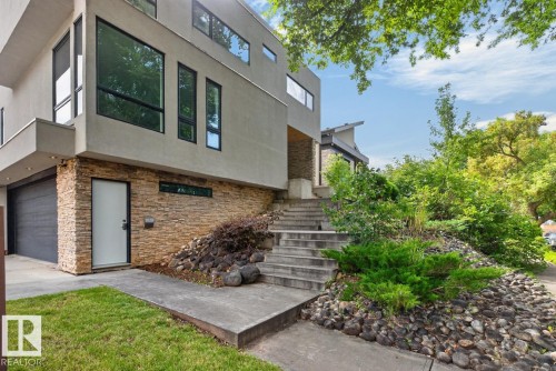 Modern exterior architecture featuring a stucco finish and stacked stone accents - 14A Birch Drive, St. Albert, AB 