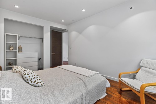 Recessed lighting, wood-finish flooring, built-in open closet with hanging rod, and a dark wood-finish interior door - 14A Birch Drive, St. Albert, AB 