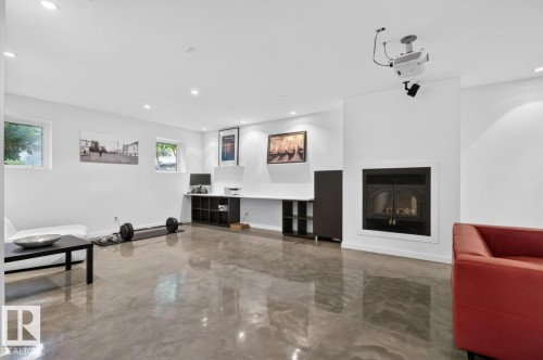 Recessed lighting, polished concrete flooring, built-in fireplace, wall-mounted projector, and integrated desk with shelving - 14A Birch Drive, St. Albert, AB 
