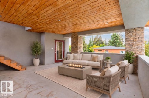 Covered outdoor patio featuring a wood-panel ceiling, built-in recessed lighting, stone-clad pillars, - 14A Birch Drive, St. Albert, AB 