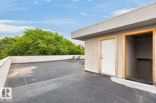 Rooftop deck featuring stucco walls, a flat roofline, and access to an enclosed utility space - 14A Birch Drive, St. Albert, AB 