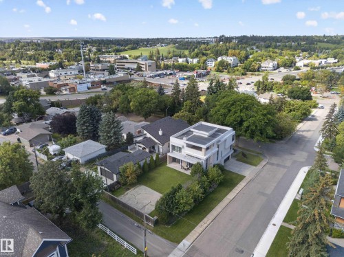 Modern architectural design with a flat roof, integrated balcony, and a prominent front lawn - 14A Birch Drive, St. Albert, AB 