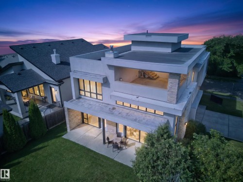 Modern architectural style featuring multiple levels, stacked stone accents, and expansive window placements - 14A Birch Drive, St. Albert, AB 