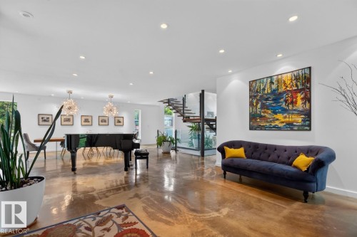 Expansive open-concept living area featuring polished concrete flooring and recessed lighting - 14A Birch Drive, St. Albert, AB 