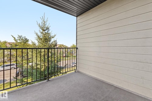 Private balcony with concrete flooring, black metal railing, and horizontal siding - #306 530 Watt Bv Sw, Edmonton, AB 