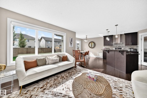 Bright living area with a large window, dark wood-finish flooring, and recessed ceiling lighting - 12035 168 Avenue Nw, Edmonton, AB 