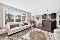 Bright living area with a large window, dark wood-finish flooring, and recessed ceiling lighting - 