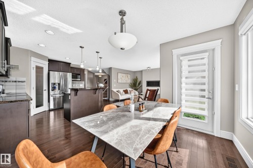 Open-concept living space with dark wood-finish flooring, recessed lighting, and a white trim exterior door - 12035 168 Avenue Nw, Edmonton, AB 