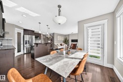 Open-concept living space with dark wood-finish flooring, recessed lighting, and a white trim exterior door - 
