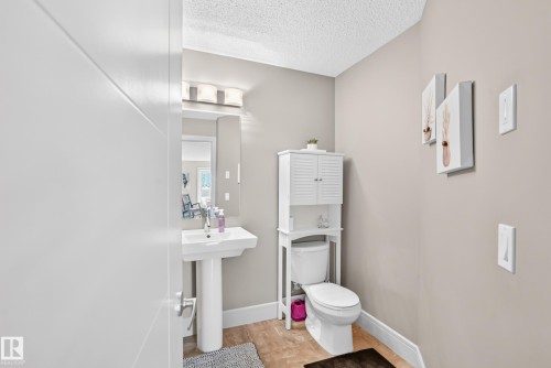 Pedestal sink with chrome faucet, wall-mounted mirror, and vanity lighting - 12035 168 Avenue Nw, Edmonton, AB 