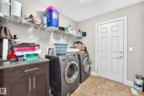 Laundry room featuring a built-in cabinetry, durable countertop, and wire shelving - 12035 168 Avenue Nw, Edmonton, AB 