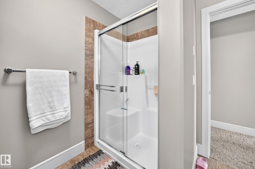 Shower enclosure with glass sliding doors, integrated shelving, and a built-in seat - 12035 168 Avenue Nw, Edmonton, AB 
