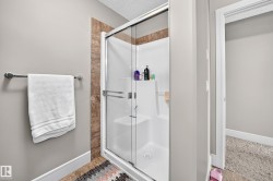 Shower enclosure with glass sliding doors, integrated shelving, and a built-in seat - 