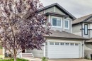Two-story exterior with light gray siding, white trim accents, attached front-facing garage, and covered front entry - 12035 168 Avenue Nw, Edmonton, AB 