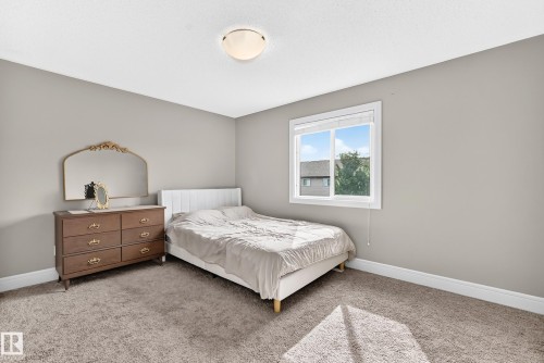 Carpeted room featuring a double-pane window, neutral wall paint, and a ceiling-mounted light fixture - 12035 168 Avenue Nw, Edmonton, AB 