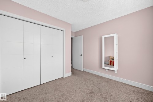 Wall-to-wall carpeting with light-colored walls, white baseboards, and a contemporary bi-fold closet - 12035 168 Avenue Nw, Edmonton, AB 