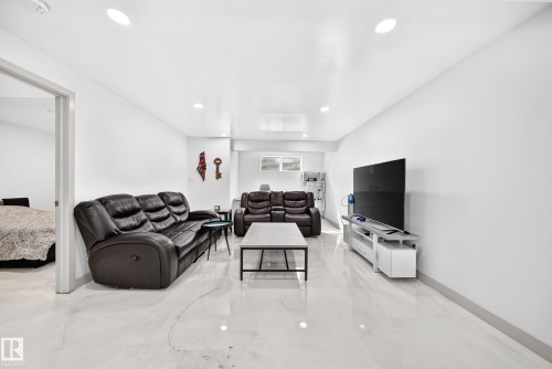 Recessed lighting illuminates this expansive space featuring light-toned tile flooring and a neutral color palette - 12035 168 Avenue Nw, Edmonton, AB 