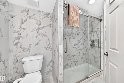 Tiled shower with sliding glass door, recessed lighting, and a white toilet - 12035 168 Avenue Nw, Edmonton, AB 