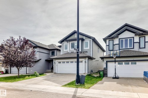 Gray siding exterior with white trim, a gabled roof, and an attached two-car garage - 12035 168 Avenue Nw, Edmonton, AB 