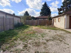 Gravel lot with perimeter fencing and a detached garage structure - 