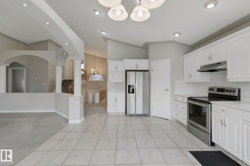 Kitchen featuring white cabinetry, stainless steel appliances, tile flooring, and recessed lighting - 16807 78 Street Nw, Edmonton, AB 