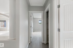 Hallway with carpet flooring, white paneled doors, and a built-in linen closet - 