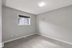 Neutral gray wall paint with white trim, carpeting, a single window with blinds, and an overhead flush-mount light fixture - 