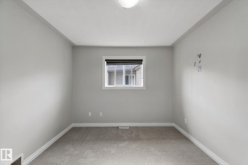 Carpeted flooring, white trim, light-colored walls, and a single window with a dark blind - 16807 78 Street Nw, Edmonton, AB 