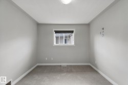 Carpeted flooring, white trim, light-colored walls, and a single window with a dark blind - 