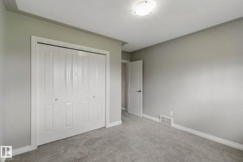 Recessed ceiling light, neutral wall color, plush carpet flooring, bi-fold closet doors, and white trim - 16807 78 Street Nw, Edmonton, AB 