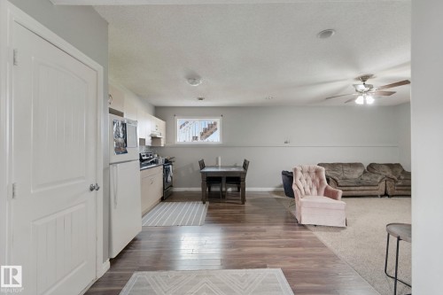 Full kitchen with white appliances, wood-finish flooring, recessed lighting, and a ceiling fan - 16807 78 Street Nw, Edmonton, AB 