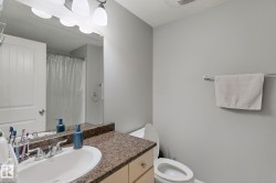 Vanity with a speckled countertop, integrated sink, and dual-handle faucet - 