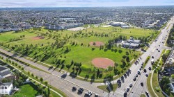Expansive green spaces with mature trees, two baseball diamonds, and a paved road network - 