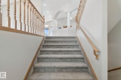 Carpeted staircase with wooden handrails and balusters - 