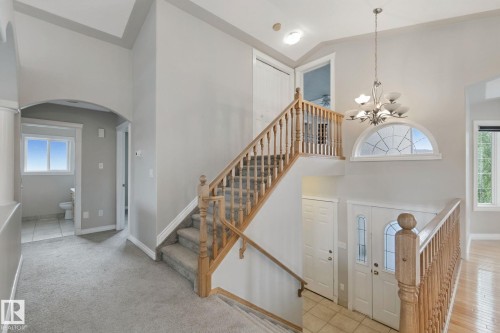 Two-story foyer with a decorative arched transom window and chandelier - 16807 78 Street Nw, Edmonton, AB 